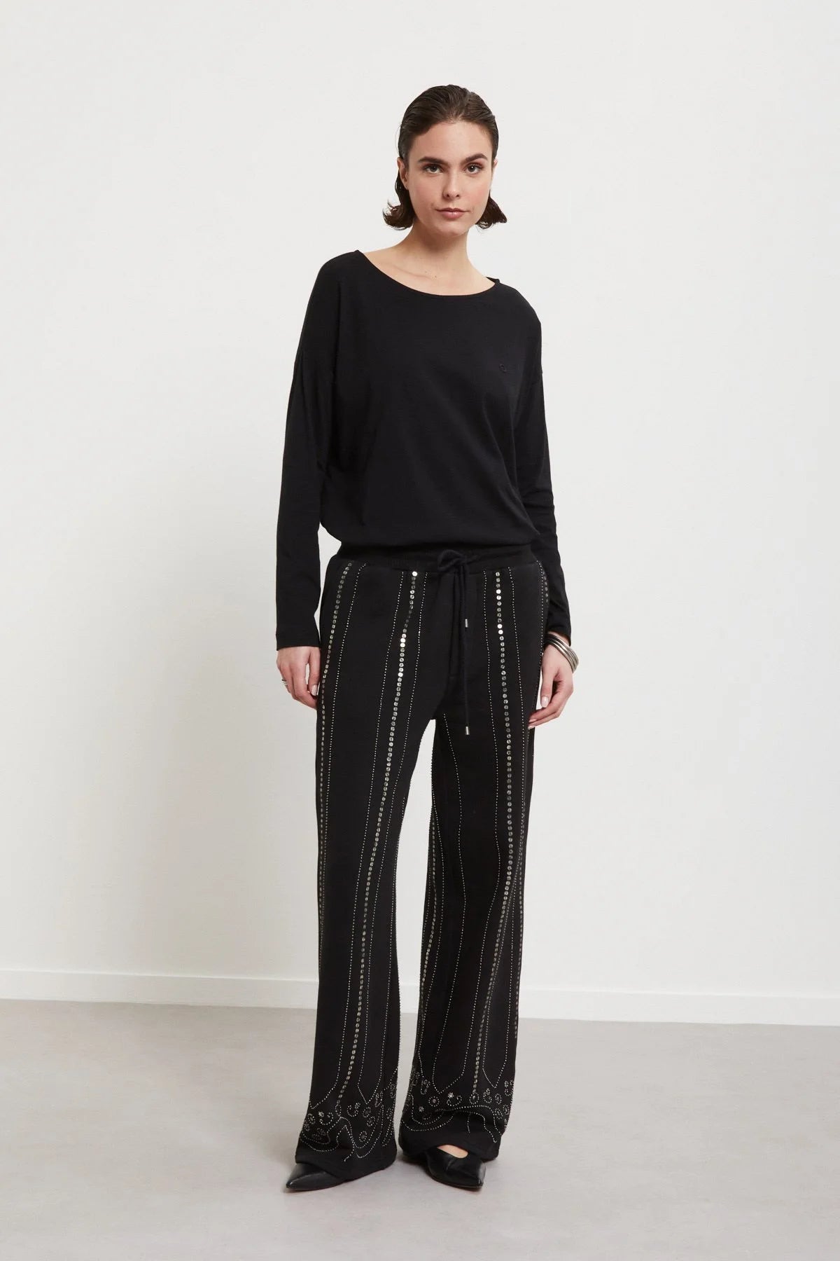 Model wearing Ottod’Ame black sequin embroidered trousers