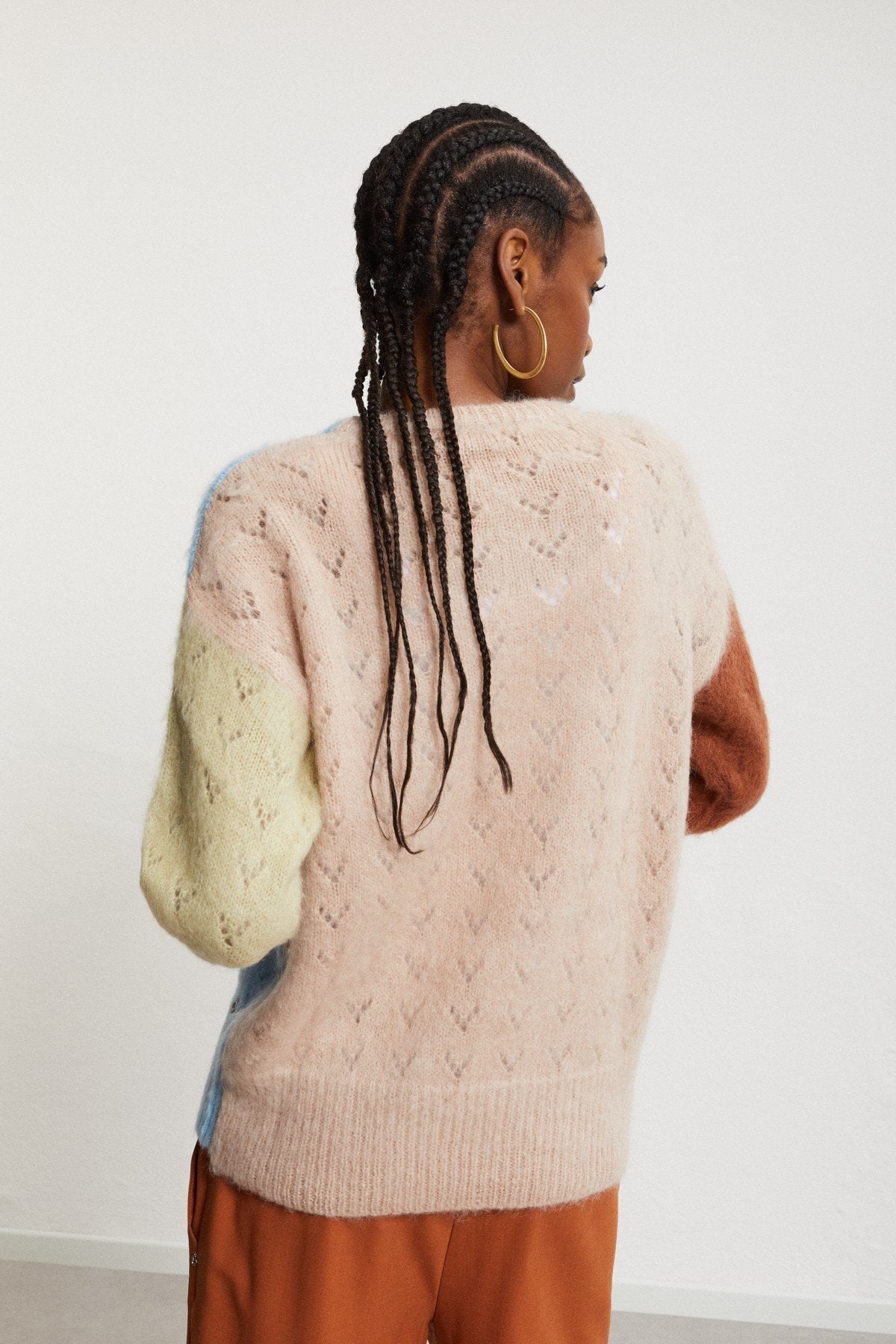 Back view of the Ottod’Ame multicolor knit jumper with a pale beige back panel and contrasting rust and pale yellow sleeves.
