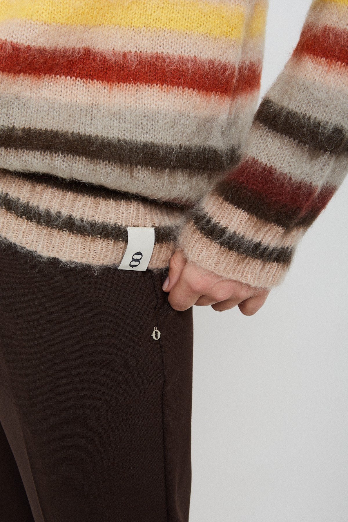 Close-up of the jumper’s striped sleeve, ribbed cuff and textured knit fabric.