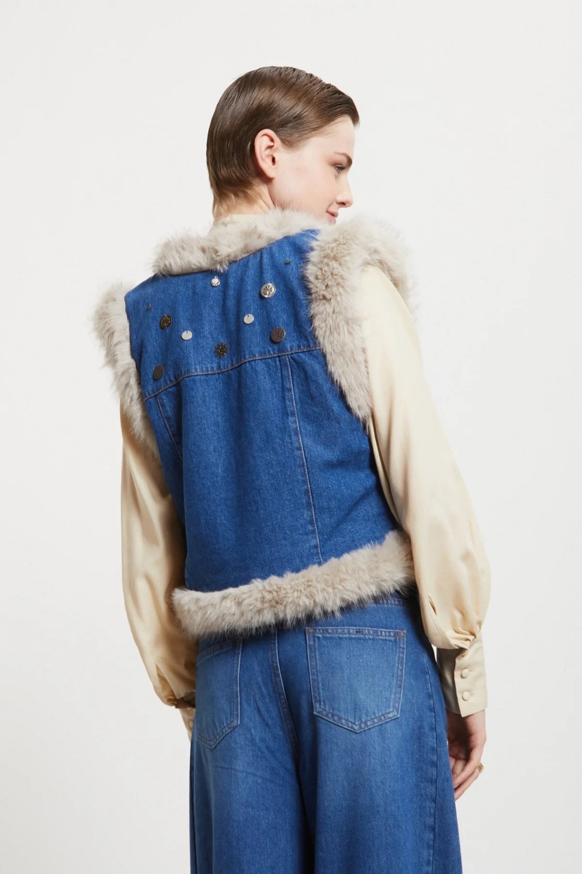 Back side of Ottod’Ame denim vest with embroidered appliqué details