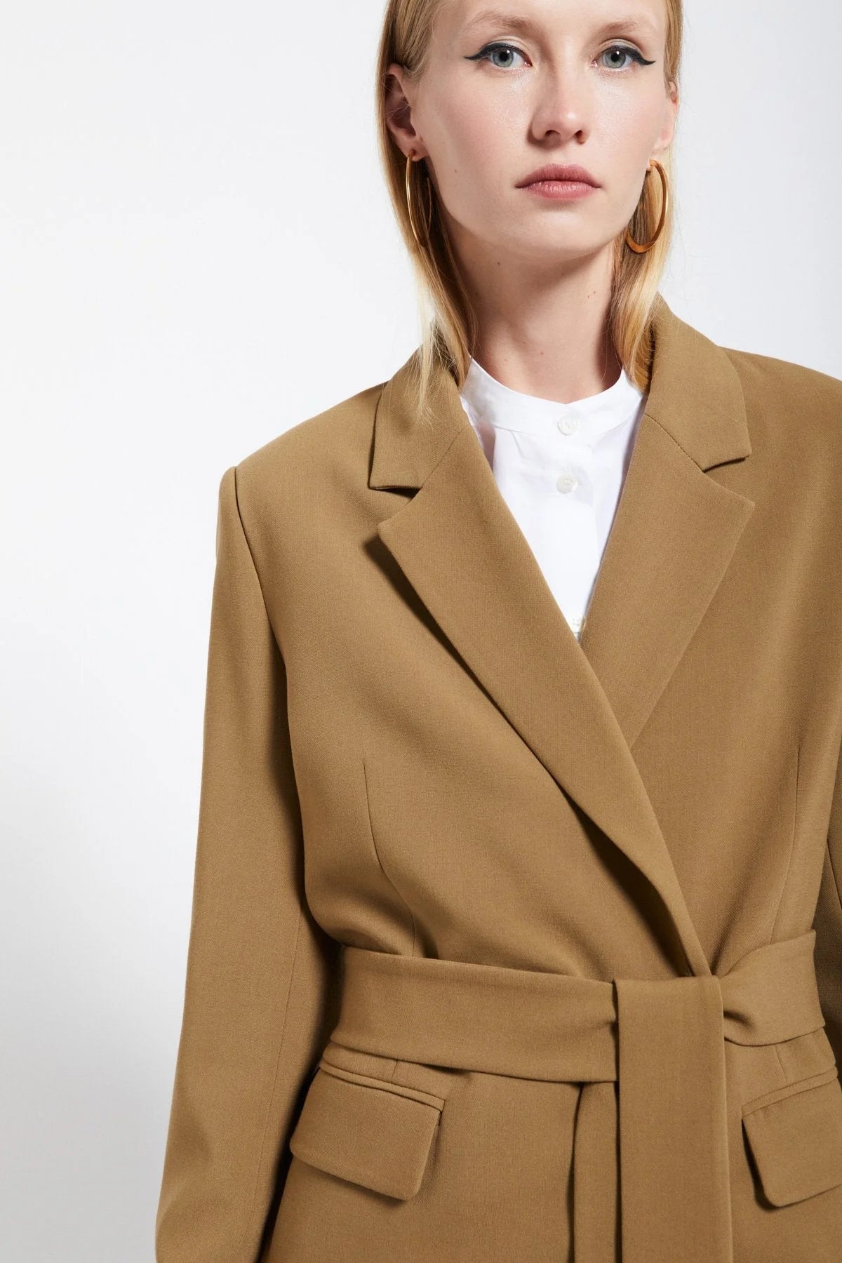 Model wearing the Ottod’Ame brown belted midi blazer, showcasing its tailored lapels and waist-defining belt.