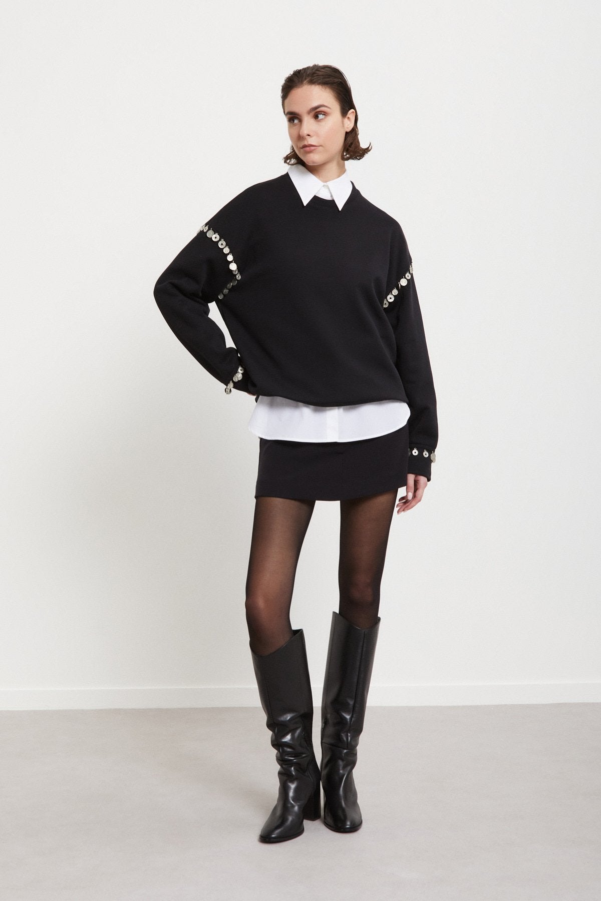 Ottod’Ame black embellished sweatshirt styled with mini shorts and knee-high boots