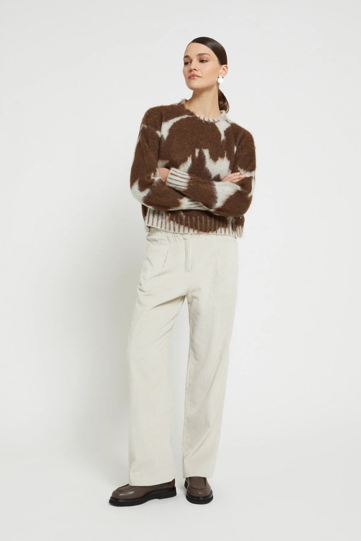 Front view of the Ottod’Ame cow print sweater styled with light cream trousers.