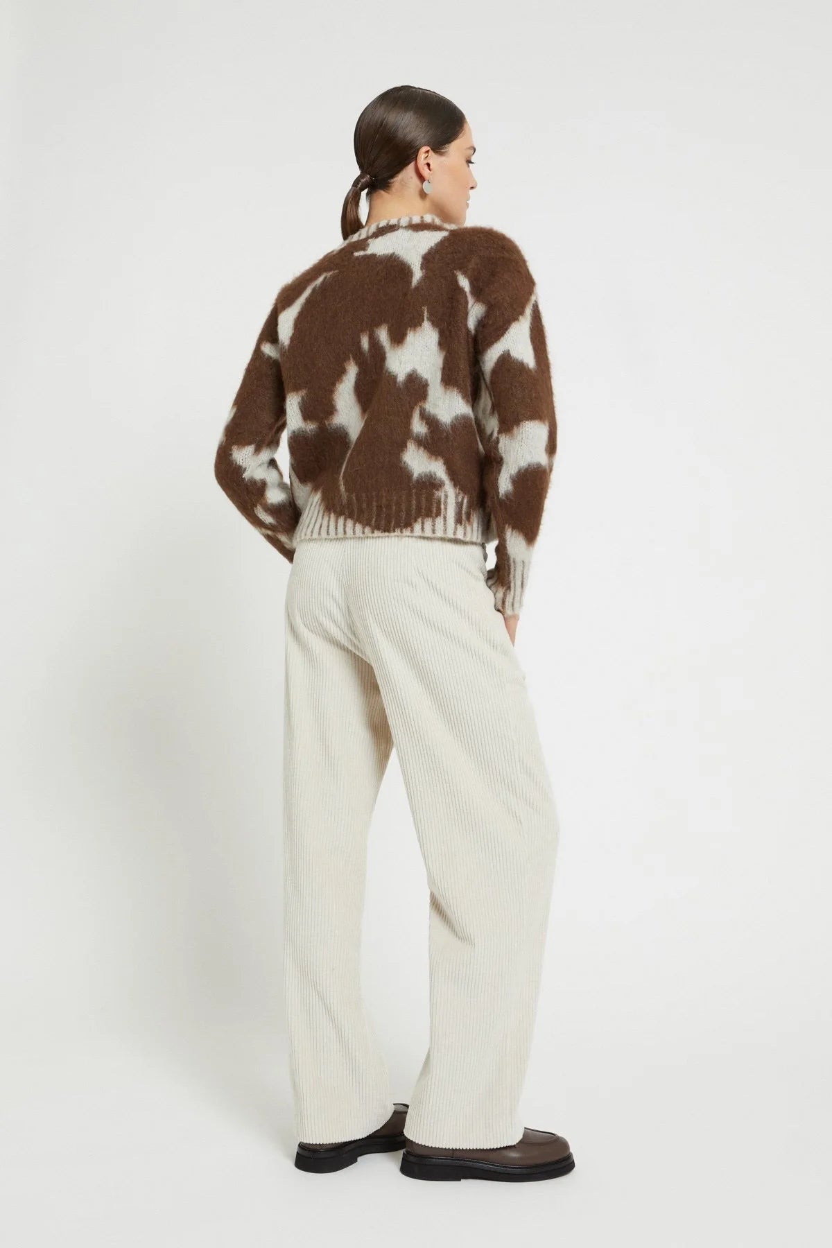 Back view of the Ottod’Ame brown and cream cow print sweater, showcasing its relaxed fit and patterned knit.