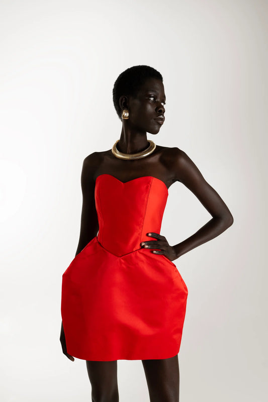 Model wearing red structured mini dress with voluminous silhouette. Sophiel