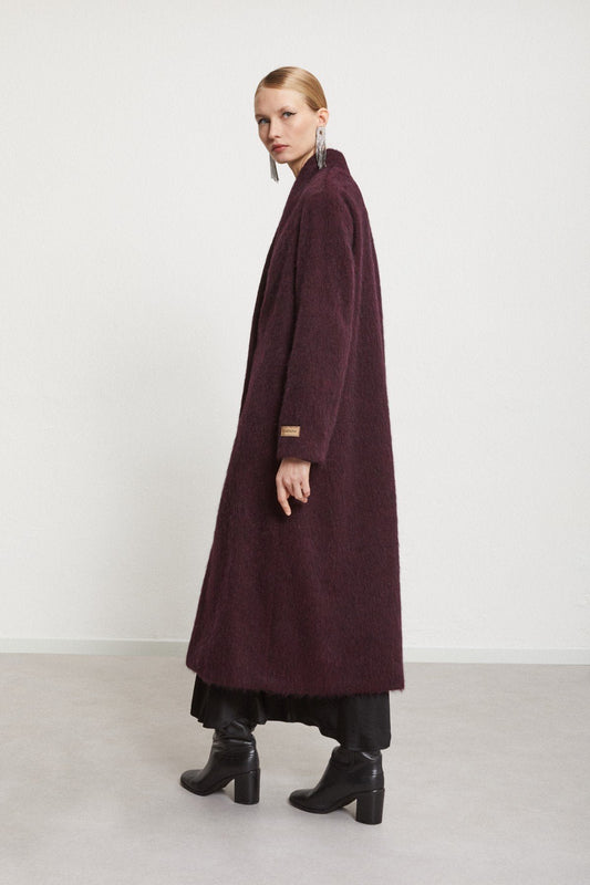 Back view of the burgundy longline coat with a minimalist silhouette.