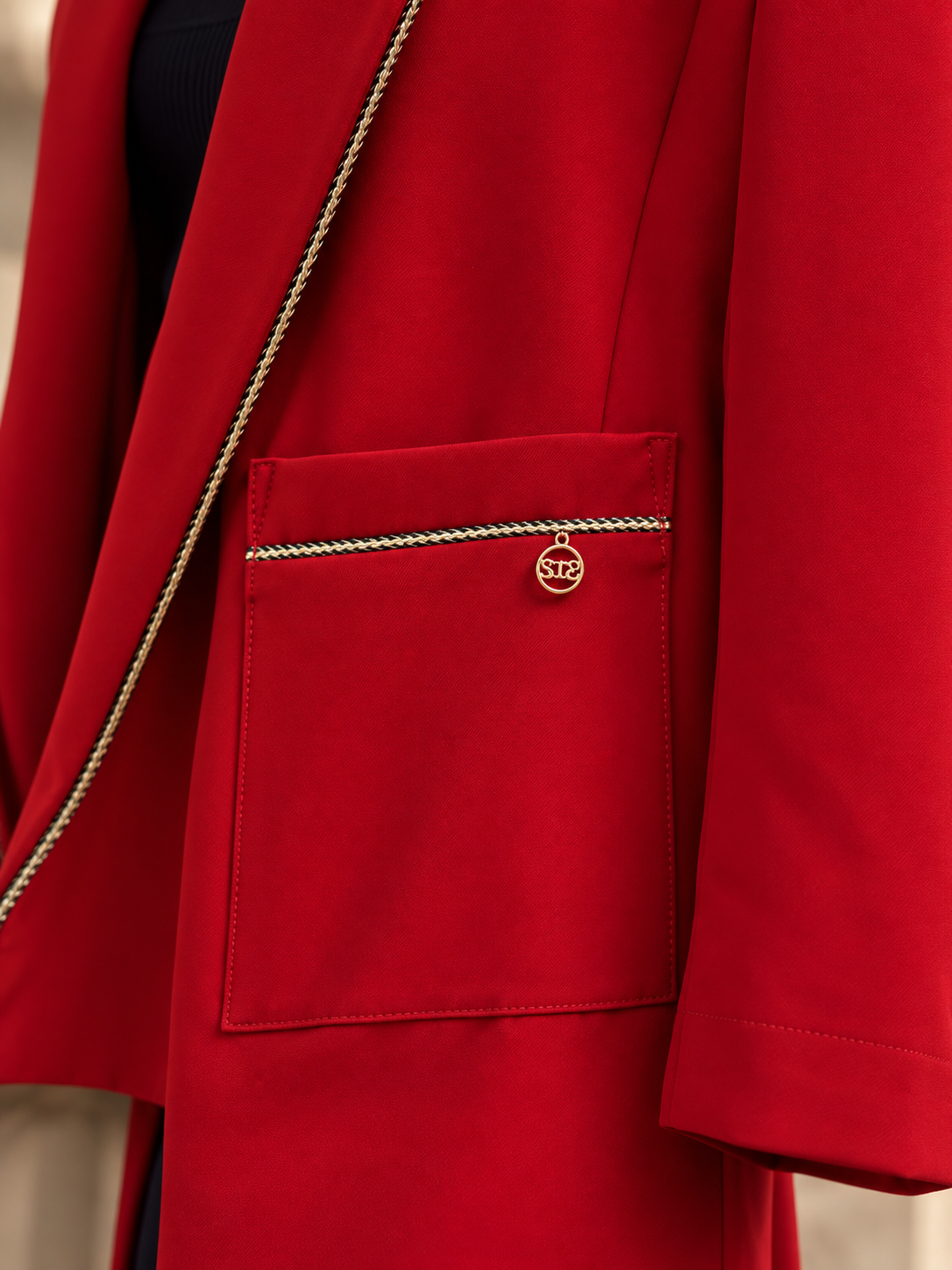 Back view of red wrap blazer with waist belt and gold chain trim