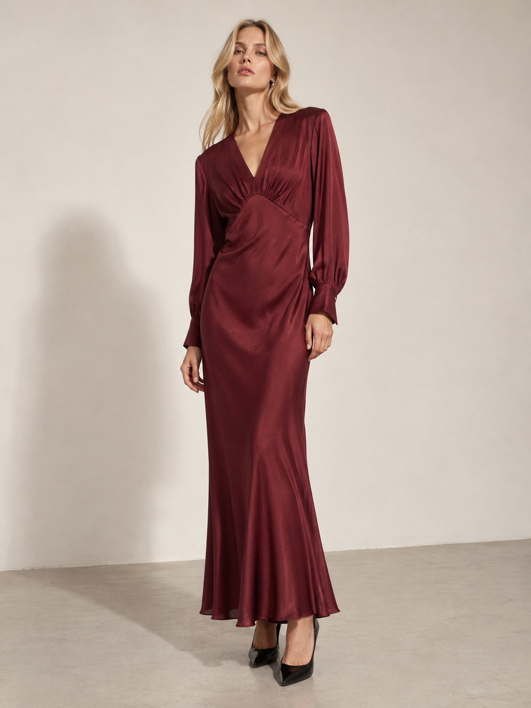 Front view of a burgundy viscose maxi dress with a gathered waist and flowing skirt.