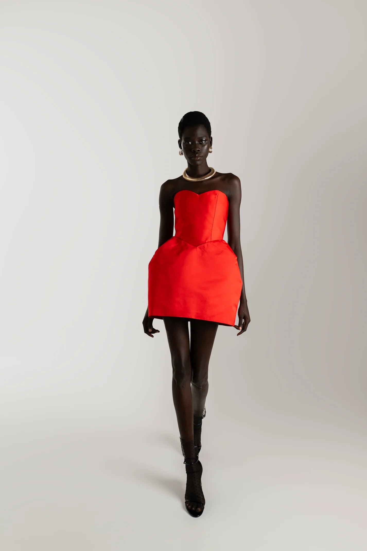 Red sculpted mini dress with fitted bodice and architectural shape